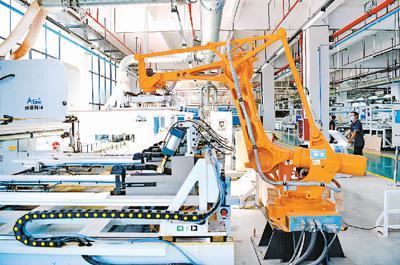 7月1日，江西省赣州市南康区家具零部件共享配料制作中心的工人在数字化生产线导入编程代码，遥控操作机械臂、传送带和数控切割机等智能设备加工零件。 朱海鹏摄（人民视觉）